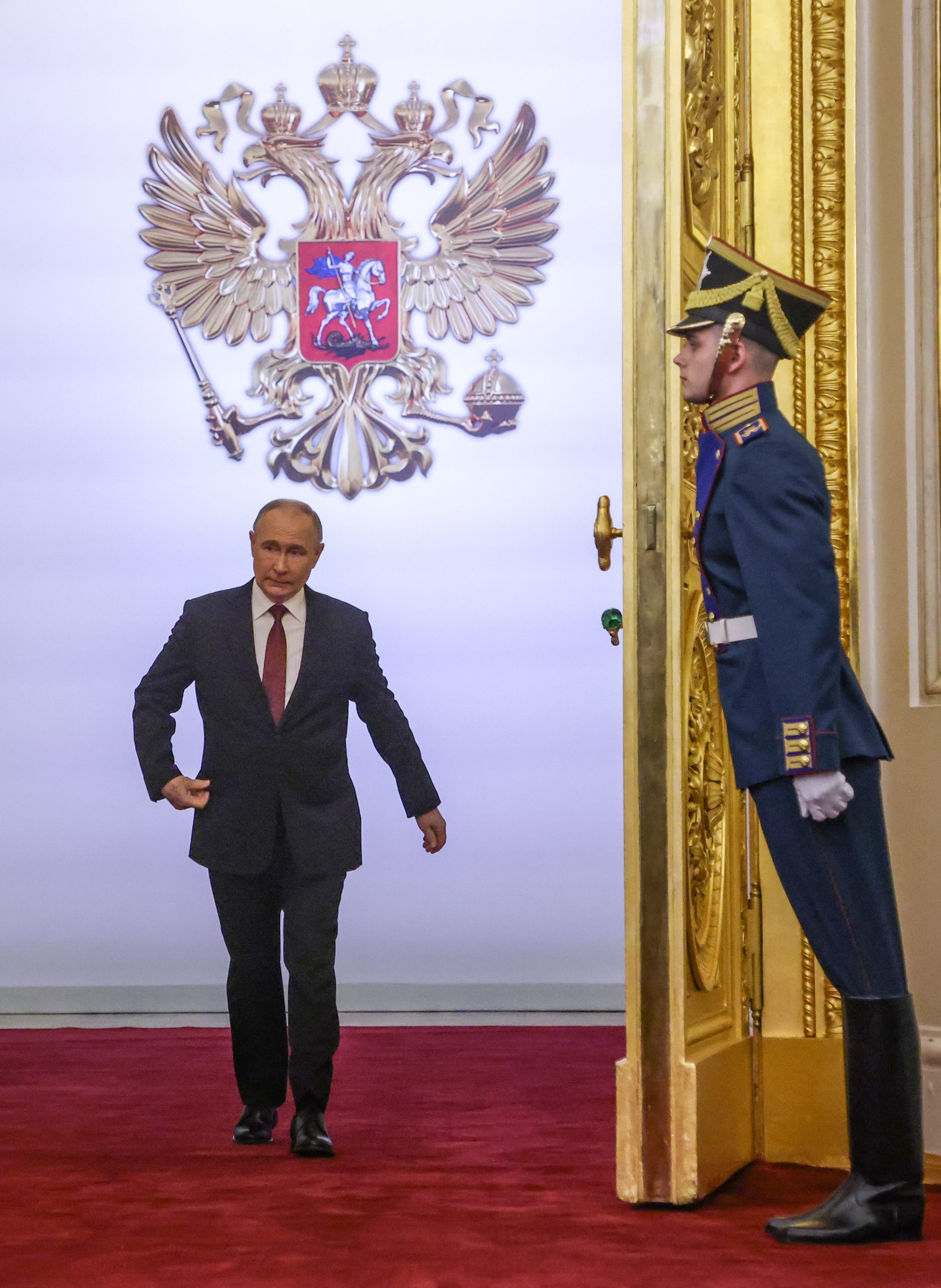 El presidente Putin entra en el salón del Gran Palacio del Kremlin, flanqueado por una guardia ceremonial cuya postura sigue el protocolo